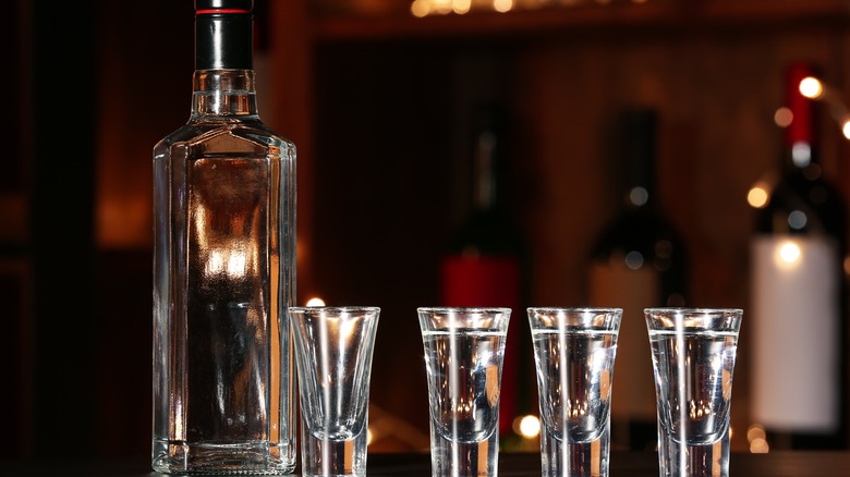 an unmarked bottle of vodka and four shots