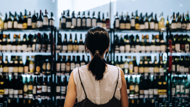 woman staring at alcohol aisle