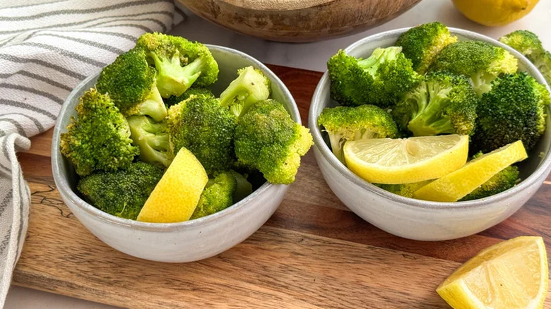 Broccoli with lemon wedges in bowls