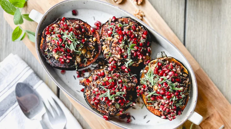 Pomegranate and wild rice stuffed acorn squash in a dish