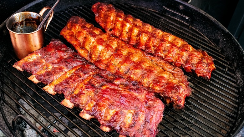 Babyback ribs on grill coated in a BBQ sauce