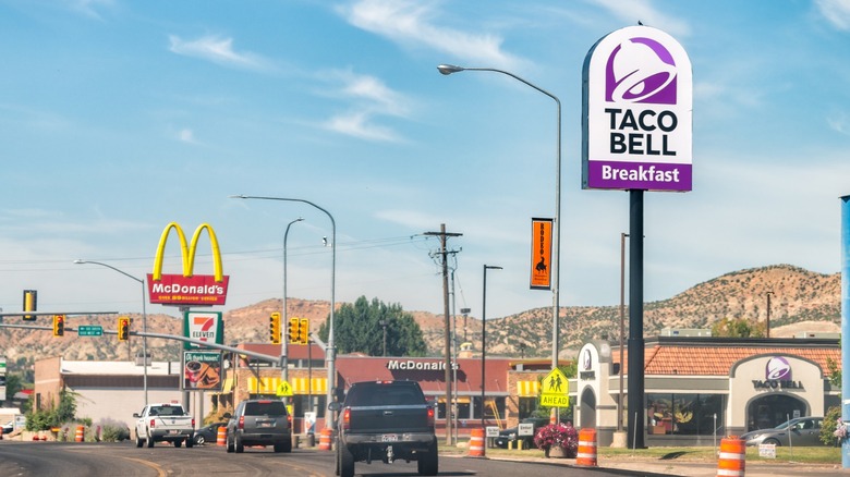 Different fast food restaurants along a road with cars driving on it in the western United States.