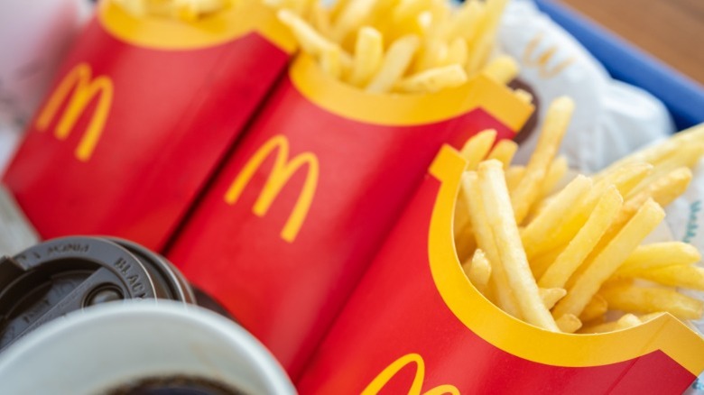 Three pouches of McDonald's french fries lined up on a tray.