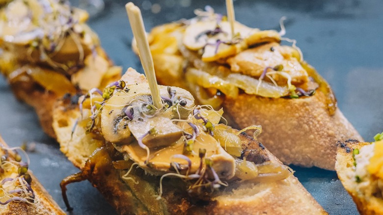 Toasted bread canapés topped with smoked oysters, mushrooms, onions, and cheese.