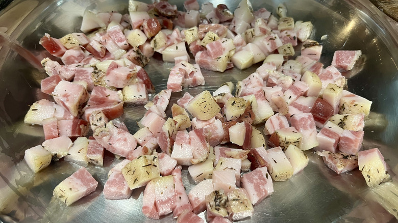 Diced guanciale cooking in a pan.