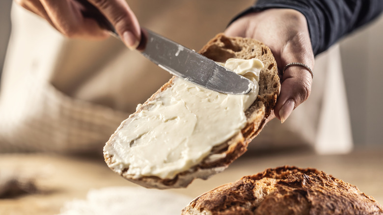 woman spreading mayonnaise on bread