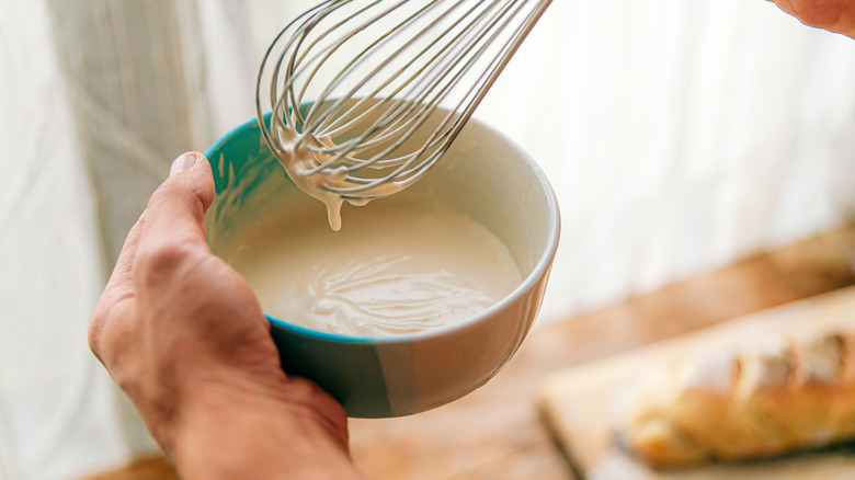 person whisking a bowl of mayo sandwich spread