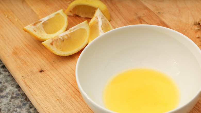 Lemon butter sauce with lemon wedges on side.