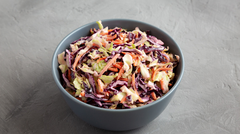 cabbage slaw in a bowl on an off white surface