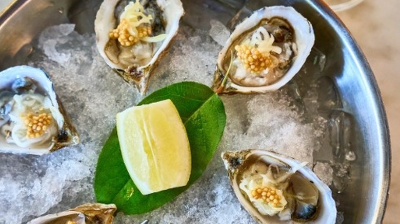 Garnished oysters served with lemon on ice at Half Shell in Seattle.