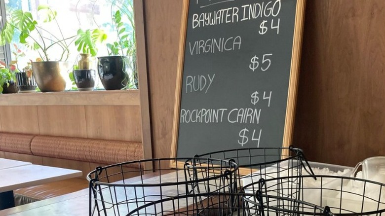 A chalkboard showing the daily fresh oyster options at Oyster Cellar in Seattle.