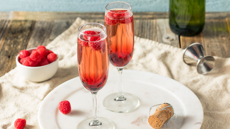 Two Kir Royale cocktails with raspberries
