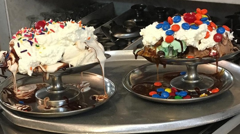 Two ice cream sundaes on a silver tray.