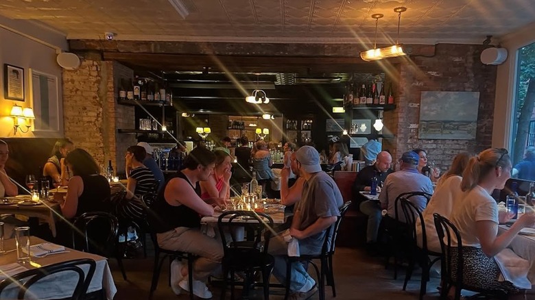 People populate tables in the dimly lit dining room at Ingas Bar.