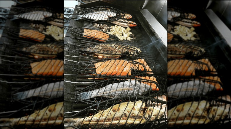 A plate of fish and a side of beets on a restaurant table.