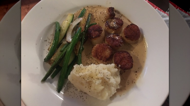 A plate of scallops and veggies at Petite Crevette.