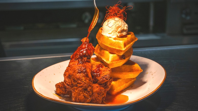 Nashville fried chicken on a plate with waffles and butter