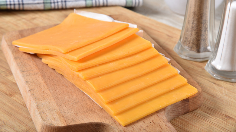 sliced cheddar cheese on a cutting board