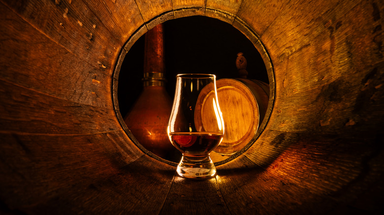 Glass of Irish whiskey in an oak barrel