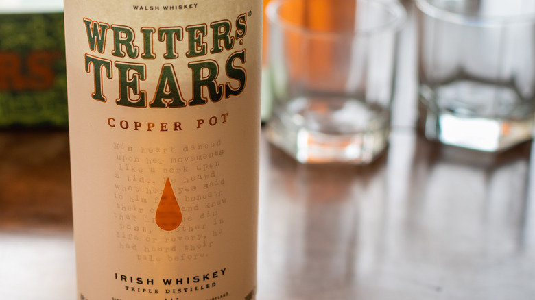 a bottle of Walsh Whiskey's Writers Tears and glasses