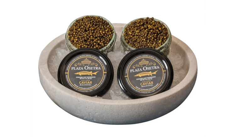 Two tins of Plaza Osetra caviar from Costco resting in a bowl of ice