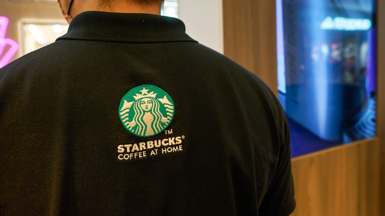Man wearing shirt with Starbucks siren logo on the back