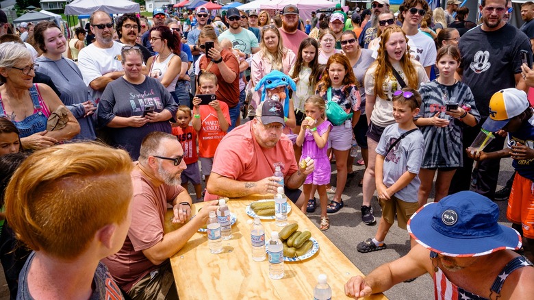 Crowd watches three people in pickle eating contest