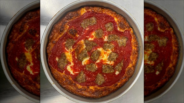 Whole deep dish sausage pizza in a pan