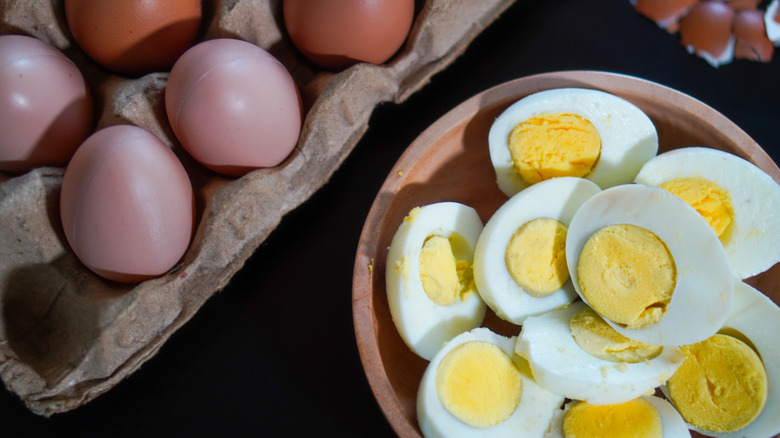 Hard boiled eggs next to eggs in shells