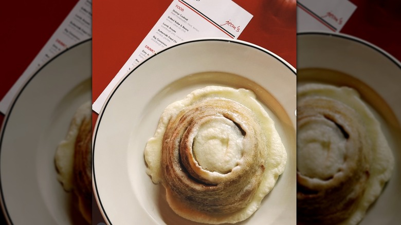 Gooey cinnamon roll on white restaurant plate