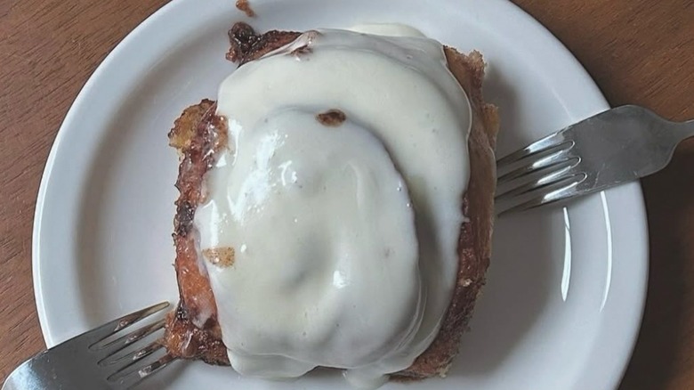 Gooey cinnamon roll on plate with fork