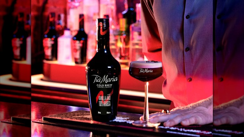 Tia Maria cold brew coffee liqueur with martini with a bar in pink light in the background