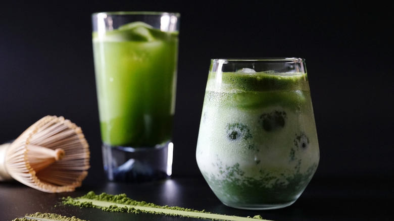 Iced matcha drinks, matcha powder, and a bamboo whisk