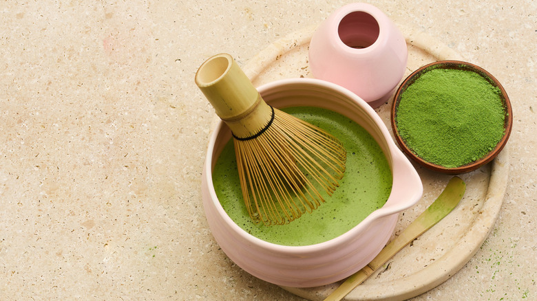 Matcha preparation in pink stoneware against a stone background