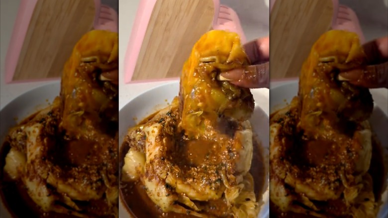 Someone lifting up a leaf from a viral cabbage boil with their fingers