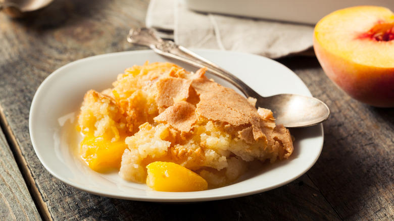 Homemade peach cobbler in a white bowl with a spoon