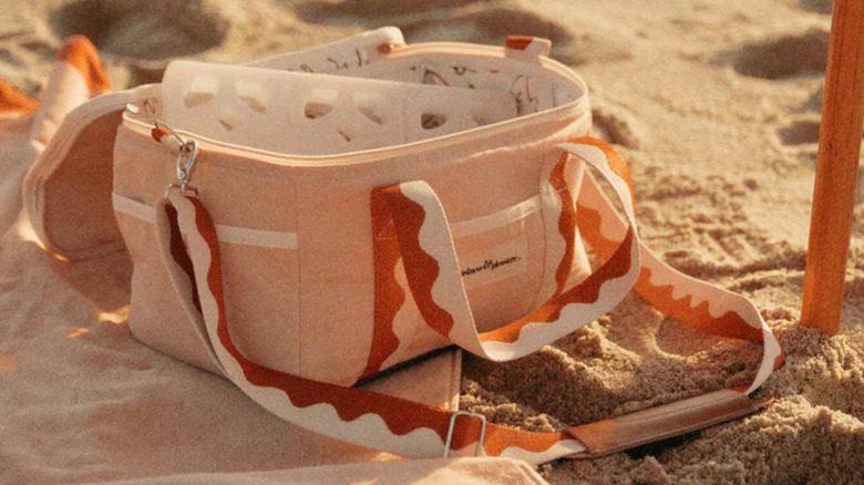 pink and red cooler bag on a sandy beach