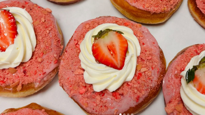 Strawberry donuts topped with fresh strawberries and cream from Rose Ave Bakery