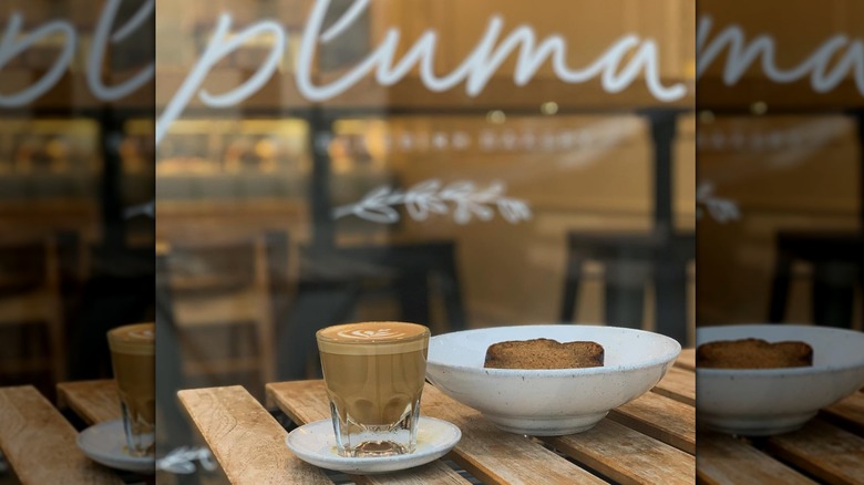 Coffee and a pastry on a table outside Pluma