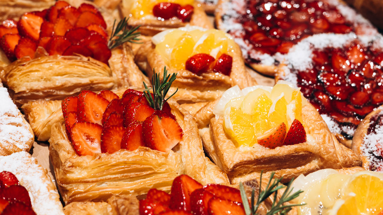 A display of different pastries topped with fresh fruit