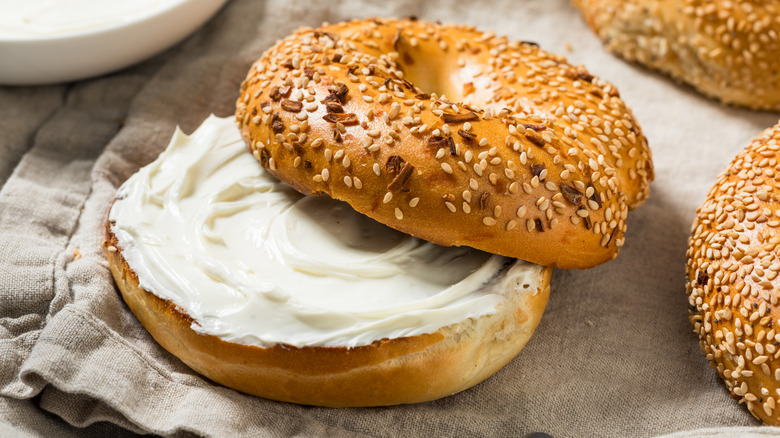Close-up of sliced sesame bagel with cream cheese