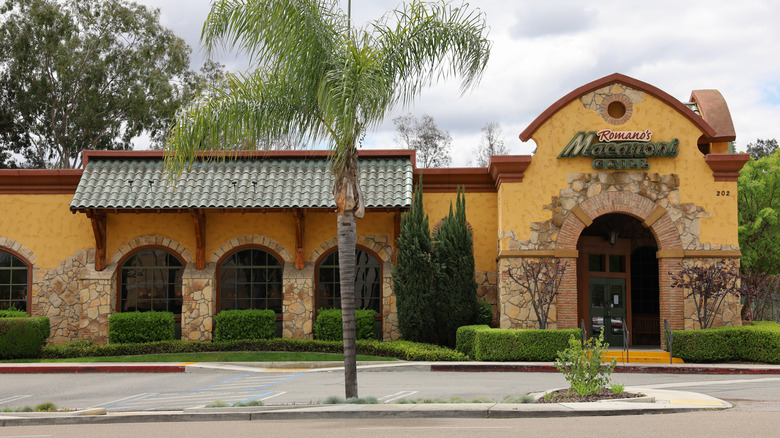 The outside of a Macaroni Grill location is mustard yellow with arched windows.