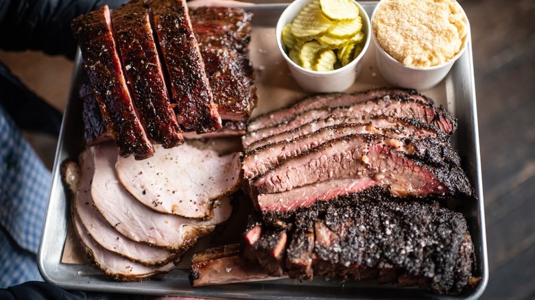 A tray loaded with succulent barbecue and sides