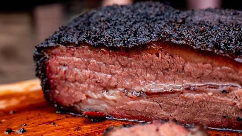 A closeup of a sliced brisket that is oozing with juices. Dark black bark and solid smoke ring to boot