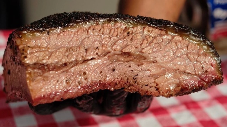 A half brisket sliced open to reveal pearlescent meat with good smoke ring and bark