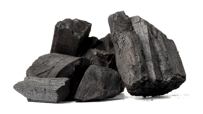 hardwood charcoal in pile on white background
