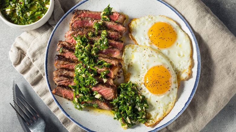 Steak and eggs topped with chimichurri