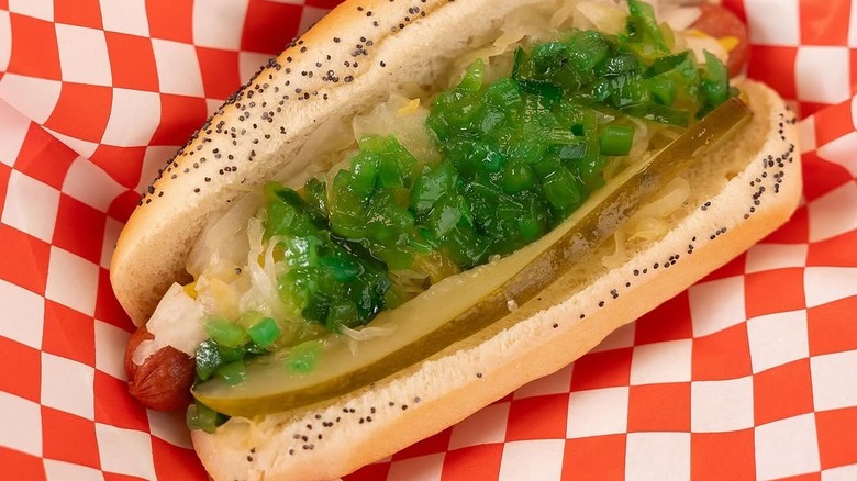 Close-up for a hot dog in a poppy seed bun with relish on top