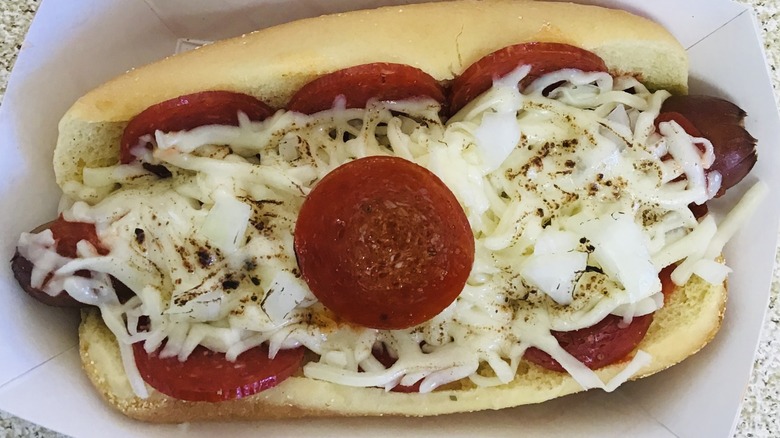 A hot dog in a bun covered with cheese and pepperoni