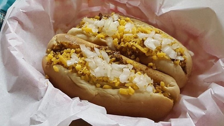Two chili cheese dogs in a red serving basket